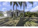 Attractive home with palm trees and mature landscaping enhancing its curb appeal at 2655 Oleander Ct, Palm Harbor, FL 34684