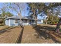 Inviting two-story home with a cozy front porch and mature trees surrounding the property at 27350 San Carlos Dr, Punta Gorda, FL 33983