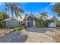 Charming teal home with paver driveway and lush landscaping at 303 68Th St, Holmes Beach, FL 34217