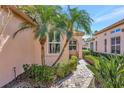 Close up of home exterior with brick walkway and lush tropical landscaping at 3872 Mira Lago Dr, Sarasota, FL 34238