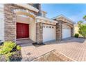 Inviting entryway with a vibrant red double door, brick accents, and a well-lit three-car garage at 4307 70Th E Ave, Ellenton, FL 34222