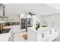 Modern kitchen with white cabinets, stainless steel appliances, and a center island with a sink at 5107 Saint Albans Ave, Sarasota, FL 34242