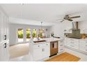 Open kitchen with white cabinetry, stainless steel appliances, and an adjacent dining area at 5107 Saint Albans Ave, Sarasota, FL 34242