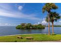 Picturesque water view showcasing lush island, condos, palm trees, and serene seating areas at 5282 Beach Se Dr # D, St Petersburg, FL 33705