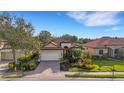 Charming front exterior of a home, featuring a paver driveway, lush landscaping, and a well-maintained lawn at 8079 36Th Street E Cir, Sarasota, FL 34243