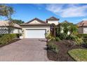 Attractive home showcasing a paver driveway, well-kept lawn, and verdant plants at 8079 36Th Street E Cir, Sarasota, FL 34243