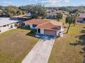 Aerial view of a well-maintained single-story home with a spacious yard and long driveway at 1058 Bounds St, Port Charlotte, FL 33952