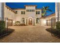 Stunning two-story home with well-maintained landscaping, a brick driveway, and a secure wrought iron gate entrance at 13315 Palmers Creek Ter, Lakewood Ranch, FL 34202