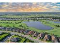 Aerial view of neighborhood showcasing waterfront homes, beautiful landscaping, lake, and community golf course at 15115 Montello Way, Lakewood Ranch, FL 34211