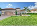 Charming front exterior with well-manicured lawn, paver driveway, mature palm trees, and a two-car garage at 15115 Montello Way, Lakewood Ranch, FL 34211