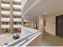 Bright hallway overlooking interior atrium with seating and multiple residential doors at 1771 Ringling Blvd # 703, Sarasota, FL 34236