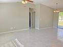 Bright and airy living room featuring neutral walls, tile floors, and sliding doors leading to the backyard at 2240 Raywood Ave, North Port, FL 34286