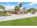 Lovely single-story home featuring a tile roof, mature landscaping, and an expansive driveway leading to a three-car garage at 265 Beaver Ct, Venice, FL 34292