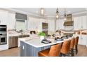 Modern kitchen features an island with seating, stainless steel appliances, and white cabinets at 26891 Victoria Pl, Punta Gorda, FL 33955