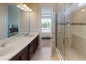 Modern bathroom with double vanity, quartz countertop, and tiled walk-in shower at 26930 Lark Ct, Punta Gorda, FL 33955