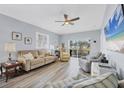 Bright living room with hardwood floors, a ceiling fan, and a sliding glass door to the backyard at 308 28Th W St, Palmetto, FL 34221