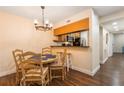 Charming dining area featuring a wood table set, a stylish chandelier, and a convenient bar pass-through to the kitchen at 3231 Beneva Rd # 101, Sarasota, FL 34232
