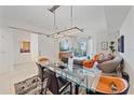 Stylish living room features modern lighting, glass dining table, open floorplan, and balcony access at 332 Cocoanut Ave # 406, Sarasota, FL 34236