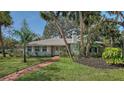 Charming one story home with brick path, chimney, neutral colors, and mature landscaping at 3716 Camino Real, Sarasota, FL 34239