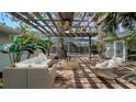 Covered patio with fan, wicker furniture, and a view of a screened pool area at 3716 Camino Real, Sarasota, FL 34239