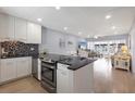 Modern kitchen opens to the living area with black countertops, white cabinets and stainless appliances at 4390 Exeter Dr # I305, Longboat Key, FL 34228