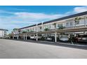 View of a covered parking area with multiple vehicles parked in assigned spaces at the condo complex at 4400 Exeter Dr # J-201, Longboat Key, FL 34228