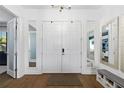 Bright foyer features double front doors, adjacent mirrors, bench seating and hardwood flooring at 4609 Antrim Dr, Sarasota, FL 34240