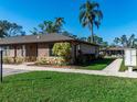 Exterior view of this single story home with well manicured lawn, side walk, mailbox, and tropical trees at 5315 11Th Street E Cir # 5315, Bradenton, FL 34203