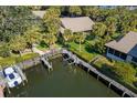 Aerial view of waterfront property showcasing a boat dock on a canal surrounded by mature trees at 6650 Schooner Bay Cir # 6650, Sarasota, FL 34231