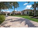 Paver driveway approaching a well-maintained estate with manicured lawns and mature landscaping at 16416 Baycross Dr, Lakewood Ranch, FL 34202