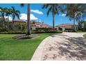 Long paver driveway leading to an impressive home with lush green lawns and mature trees at 16416 Baycross Dr, Lakewood Ranch, FL 34202