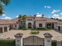 Elegant Mediterranean-style home showcasing a stately entrance, circular driveway, and manicured landscaping at 16416 Baycross Dr, Lakewood Ranch, FL 34202