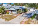 Quaint single-Gathering home features mature landscaping, a metal roof, and a private driveway leading to a detached garage at 1687 Arlington St, Sarasota, FL 34239