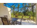 A screened-in lanai, featuring a patio table with seating and a lounge chair, perfect for outdoor relaxation and entertaining at 20170 Benissimo Dr, Venice, FL 34293