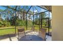 Relaxing screened lanai features a patio table and chaise lounge with views of the backyard at 20170 Benissimo Dr, Venice, FL 34293