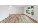 Bright living room featuring stylish wood-look floors, a large window, and fresh paint at 22151 Lancaster Ave, Port Charlotte, FL 33952