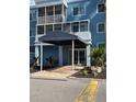 Close up view of building entrance with awning and landscaping at 2755 Coconut Bay Ln 1K # 119, Sarasota, FL 34237