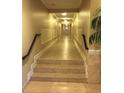 Long hallway with tile flooring, decorative wall trim, and overhead lighting at 2755 Coconut Bay Ln 1K # 119, Sarasota, FL 34237