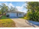 Charming single-story home featuring a well-manicured lawn, palm tree, and attached single car garage at 3311 19Th E St, Bradenton, FL 34208