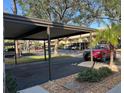 Carport parking featuring manicured landscaping and adjacent visitor spaces at 380 Three Lakes Ln # B, Venice, FL 34285