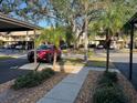 Community parking area with lush landscaping and convenient access to residences at 380 Three Lakes Ln # B, Venice, FL 34285