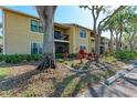 Charming condo exterior surrounded by mature trees, lush landscaping, and inviting balcony at 4061 Crockers Lake Blvd # 2611, Sarasota, FL 34238