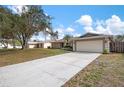 Wide driveway leading to a well-maintained home with mature trees in a sunny neighborhood at 4411 Violet Ave, Sarasota, FL 34233