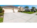 Expansive driveway leading to a three-car garage, surrounded by lush landscaping at 5063 Timber Chase Way, Sarasota, FL 34238