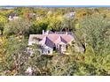 Overhead view of the home with screened lanai, nestled amidst lush trees and greenery at 67 Sugar Mill Dr, Osprey, FL 34229