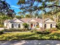 Charming one-story home features arched windows, a red door, and well-manicured landscaping at 67 Sugar Mill Dr, Osprey, FL 34229