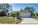 Charming single-story home with a manicured lawn, a two-car garage, and lush landscaping at 6705 20Th W Ave, Bradenton, FL 34209