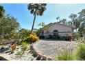 Beautiful home featuring gravel driveway and meticulously landscaped yard with lush greenery at 746 Plymouth St, Sarasota, FL 34242