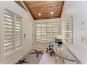 Bright foyer with a glass table, modern rug, and natural light streaming through shuttered windows at 7921 4Th W Ave, Bradenton, FL 34209