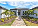 Beautiful single-story home with manicured landscaping and brick paver walkway leading to the front entrance at 8487 Lindrick Ln, Bradenton, FL 34202